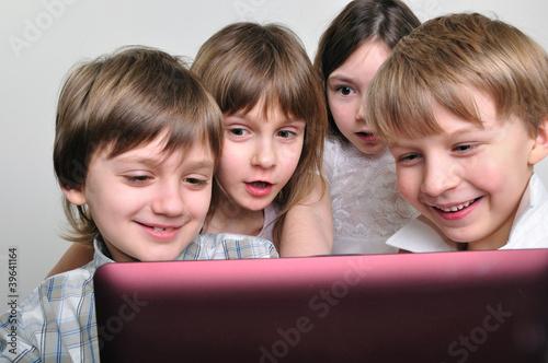 Photo: group of children friends playing computer games group of children friends playing computer games