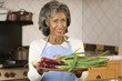Senior African woman holding plate of vegetables