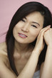 Asian woman resting head on hands