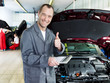 Photo: Master mechanic in a garage shows thumb up for good service Master mechanic in a garage shows thumb up for good service