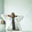 Senior African male doctor with arms behind head
