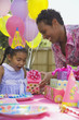 African girl receiving gift at birthday party