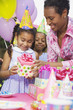 African girl receiving gift at birthday party
