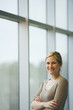 Businesswoman with arms crossed next to window