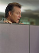 Businessman looking over cubicle wall