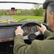 Senior Asian man driving old fashioned car