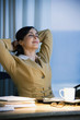 Hispanic businesswoman with hands behind head