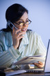 Hispanic businesswoman working in pajamas