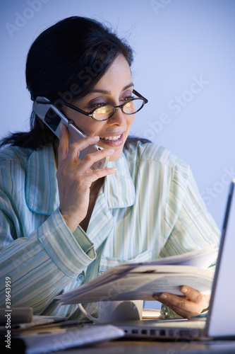 Photo: Hispanic businesswoman working in pajamas Hispanic businesswoman working in pajamas
