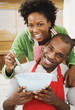 African American couple baking in kitchen