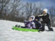 Mother pushing children on sled