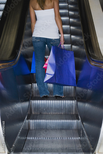 Photo: Woman on escalator with shopping bags Woman on escalator with shopping bags