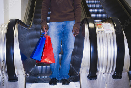 Photo: African man on escalator with shopping bags African man on escalator with shopping bags