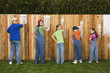 Mixed Race family painting fence