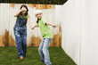 Mother and daughter painting fence