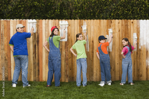 Photo: Mixed Race family painting fence Mixed Race family painting fence