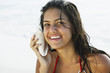 South American woman listening to seashell