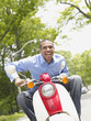 African American man riding motor scooter