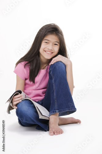 Photo: Little girl sitting on floor reading a magazine Little girl sitting on floor reading a magazine