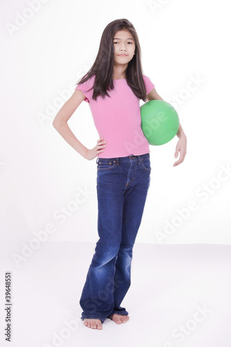Photo: Ten year old Asian girl holding green ball Ten year old Asian girl holding green ball