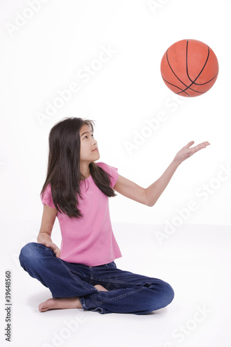 Photo: Ten year old Asian girl tossing basketball Ten year old Asian girl tossing basketball