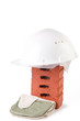 Construction concept with clay brick, hard hat and mittens