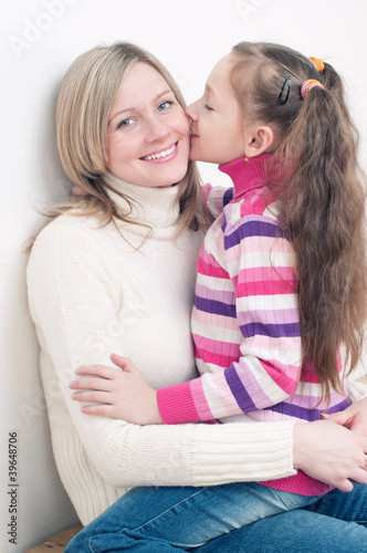 Photo: Happy young woman sitting on the floor with her little daughter Happy young woman sitting on the floor with her little daughter