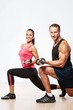 Athletic man and woman with a dumbells.