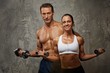Athletic man and woman with a dumbells.