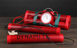 Timebomb made of dynamite on wooden table on grey background