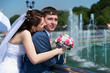 Happy bride and groom with bouquet at wedding walk
