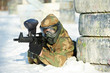 paintball player with marker at winter outdoors