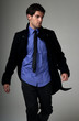Photo: Young man fashion suit walking over grey Young man fashion suit walking over grey