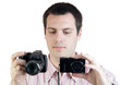 Young man with two digital cameras isolated on white