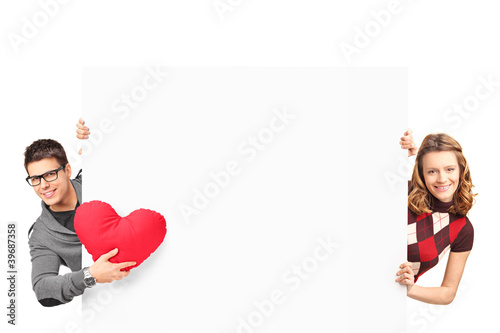 Photo: Smiling girl and boy with heart shaped pillow posing behind a wh Smiling girl and boy with heart shaped pillow posing behind a wh