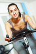 Photo: A young woman riding an exercise bike A young woman riding an exercise bike
