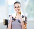 Photo: dumbbell in hand of working out young smiling female dumbbell in hand of working out young smiling female