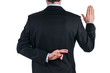 young businessman in suit telling a lie with the fingers crossed