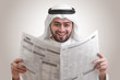 arabian businessman shocked while reading newspaper