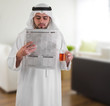 arabian business man at home drinking tea & reading news