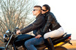 Young happy couple ready to go on a ride with motorcycle