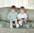 Two reading boys. With paper book and electronic book