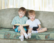 Two reading boys. With paper book and electronic book