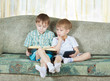 Two reading boys. With paper book and electronic book