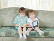 Two reading boys. With paper book and electronic book