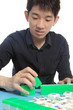 Chinese man play Mahjong, traditional China gamble.