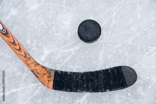 Photo: ice hockey stick and puck on ice ice hockey stick and puck on ice