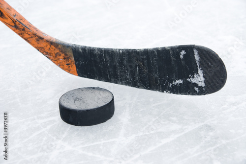 Photo: ice hockey stick and puck on ice ice hockey stick and puck on ice