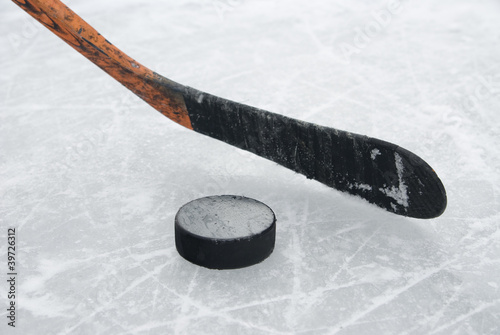 Photo: ice hockey stick and puck on ice ice hockey stick and puck on ice