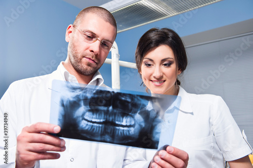 Photo: Dentist and assistant checking x-ray at dental clinic Dentist and assistant checking x-ray at dental clinic